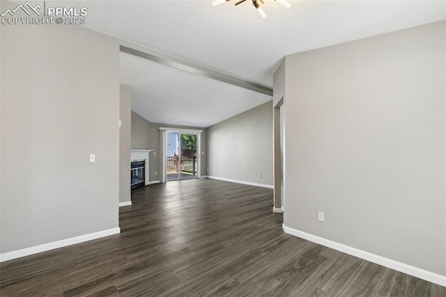 4680 Pika Pt, Colorado Springs, CO 80922 - unfurnished living room featuring dark wood-type flooring, vaulted ceiling, and a glass covered fireplace