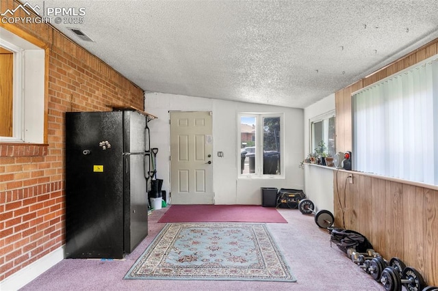 8991 Hickory Pl, Thornton, CO 80229 - exercise room featuring carpet, a textured ceiling, brick wall, and lofted ceiling