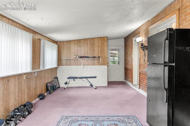 8991 Hickory Pl, Thornton, CO 80229 - kitchen with freestanding refrigerator, wooden walls, carpet flooring, open shelves, and brick wall