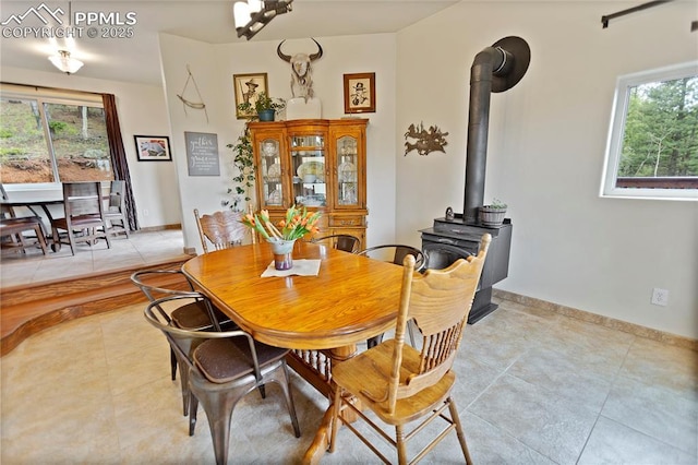 1522 Monarch Dr, Cripple Creek, CO 80813 - dining room featuring light tile patterned floors, a wood stove, and healthy amount of natural light