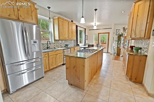 1522 Monarch Dr, Cripple Creek, CO 80813 - kitchen featuring stainless steel appliances, a center island, decorative backsplash, dark stone countertops, and light tile patterned floors