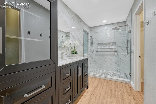 123 Wheat Ridge St, Palmer Lake, CO 80133 - full bathroom featuring a marble finish shower, vanity, wood finished floors, and recessed lighting
