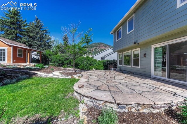 123 Wheat Ridge St, Palmer Lake, CO 80133 - view of grassy yard with a patio area and an outdoor structure