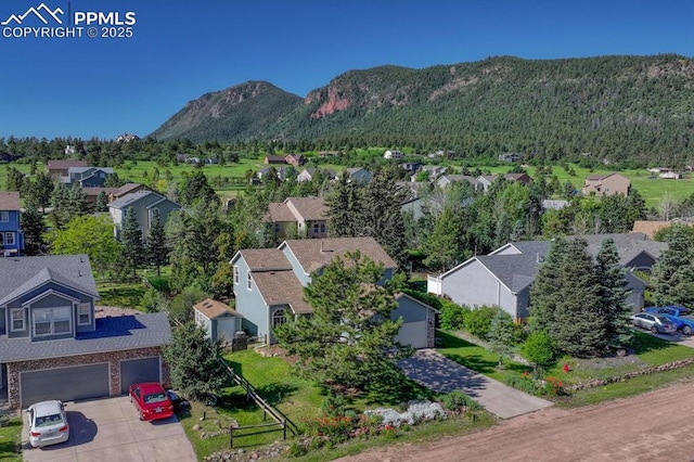 123 Wheat Ridge St, Palmer Lake, CO 80133 - aerial perspective of suburban area with a mountainous background and a heavily wooded area