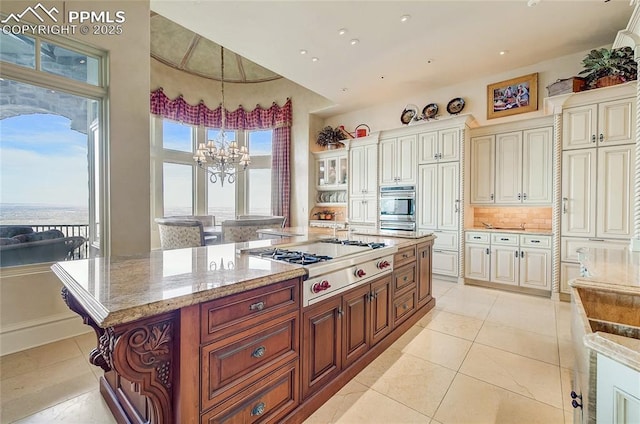 910 Grey Mountain Pt, Colorado Springs, CO 80906 - kitchen featuring stainless steel gas stovetop, a chandelier, light stone countertops, hanging light fixtures, and backsplash