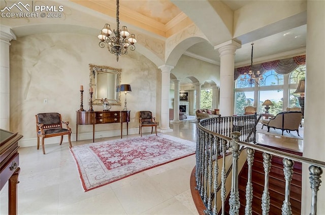 910 Grey Mountain Pt, Colorado Springs, CO 80906 - entryway featuring a chandelier, ornate columns, arched walkways, crown molding, and a fireplace