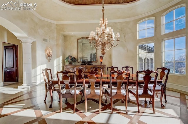 910 Grey Mountain Pt, Colorado Springs, CO 80906 - dining room featuring inlaid floor details, ornate columns, healthy amount of natural light, a high ceiling, and arched walkways