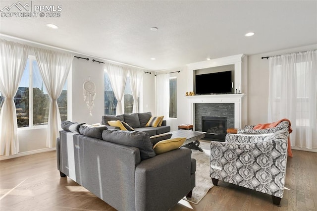 13437 Park Meadows Dr, Peyton, CO 80831 - living room with a stone fireplace, wood finished floors, and recessed lighting