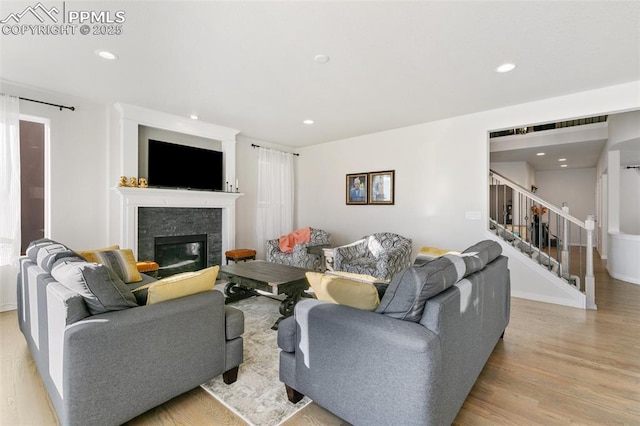13437 Park Meadows Dr, Peyton, CO 80831 - living room featuring a glass covered fireplace, wood finished floors, recessed lighting, and stairway