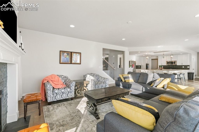 13437 Park Meadows Dr, Peyton, CO 80831 - living room featuring stairs, light wood-style floors, a fireplace, and recessed lighting
