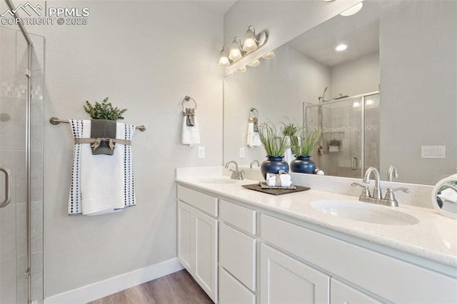 10238 Odin Dr, Colorado Springs, CO 80924 - bathroom with double vanity, a stall shower, and wood finished floors