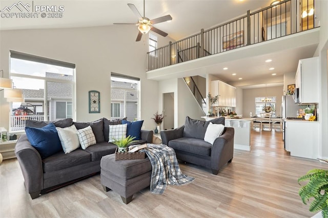 10238 Odin Dr, Colorado Springs, CO 80924 - living area with high vaulted ceiling, light wood-style floors, ceiling fan, a chandelier, and stairs