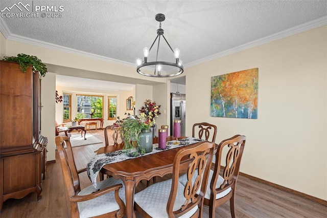 2505 Wimbleton Ct, Colorado Springs, CO 80920 - dining area with a chandelier, light wood-style flooring, a textured ceiling, and ornamental molding