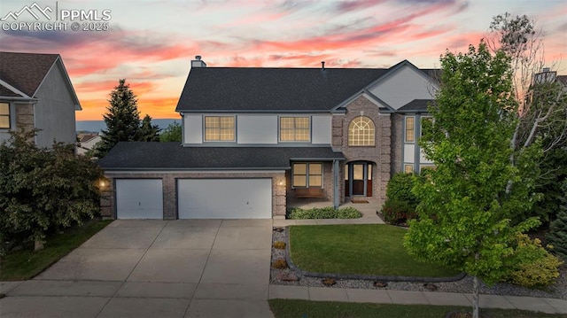 2505 Wimbleton Ct, Colorado Springs, CO 80920 - traditional-style home featuring concrete driveway, a chimney, brick siding, a front yard, and a garage