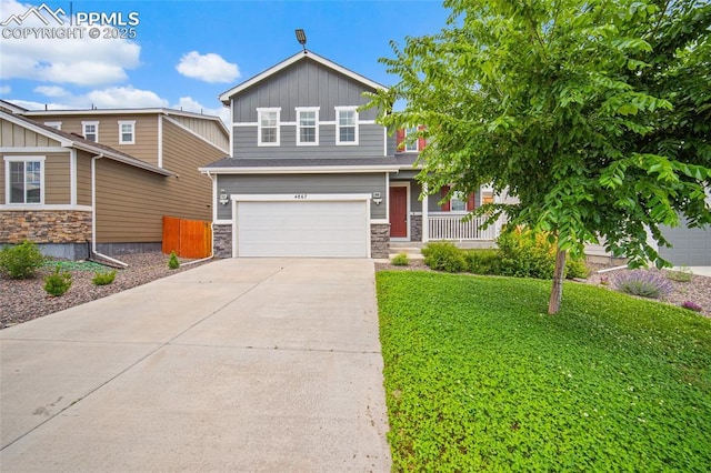 4867 Wolf Moon Dr, Colorado Springs, CO 80911 - craftsman-style house with a garage, driveway, stone siding, covered porch, and board and batten siding