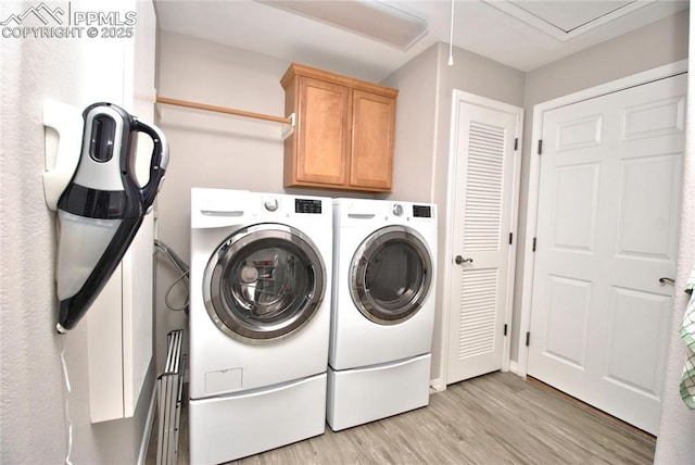 4201 Stonesthrow Vw, Colorado Springs, CO 80922 - laundry area featuring washing machine and clothes dryer, light wood-style floors, cabinet space, and attic access