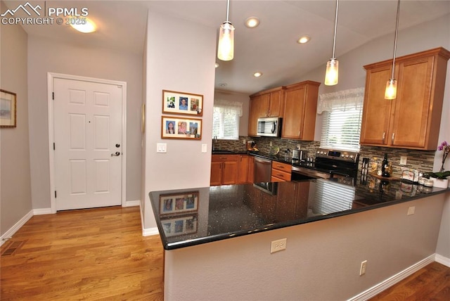 4201 Stonesthrow Vw, Colorado Springs, CO 80922 - kitchen featuring appliances with stainless steel finishes, backsplash, a peninsula, light wood-type flooring, and healthy amount of natural light