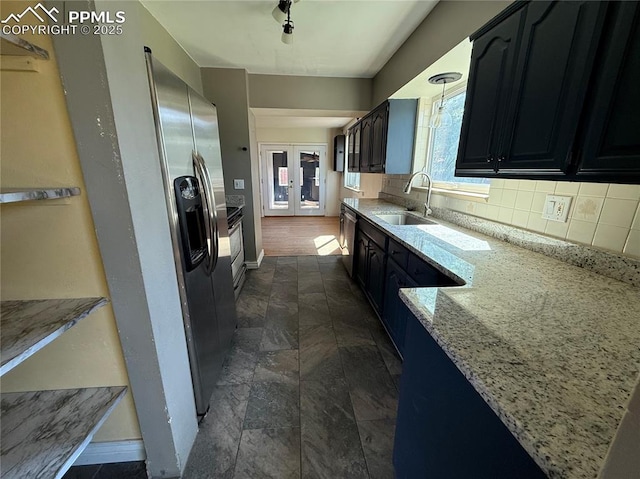 251 Fay Dr, Colorado Springs, CO 80911 - kitchen with decorative backsplash, dark cabinetry, light stone counters, dark stone finish flooring, and stainless steel dishwasher