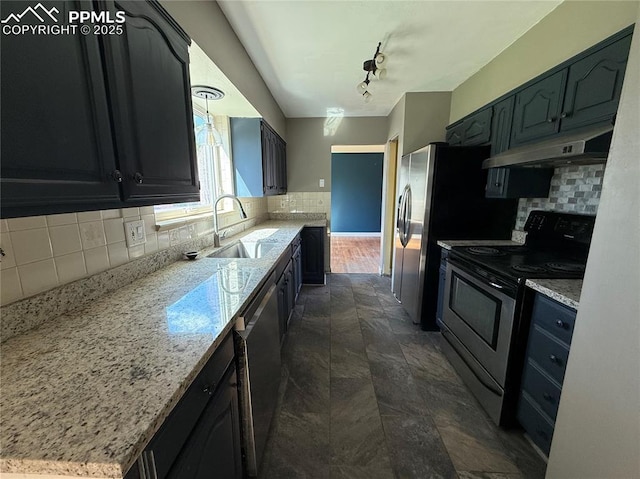 251 Fay Dr, Colorado Springs, CO 80911 - kitchen with stainless steel appliances, under cabinet range hood, decorative backsplash, and light stone countertops