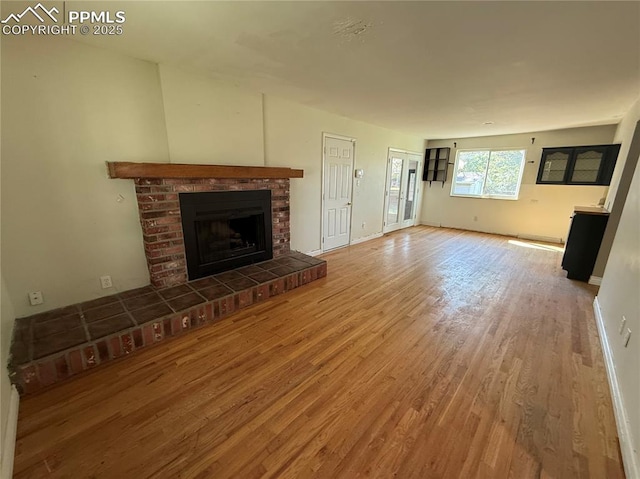 251 Fay Dr, Colorado Springs, CO 80911 - unfurnished living room featuring wood finished floors and a brick fireplace