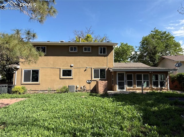 251 Fay Dr, Colorado Springs, CO 80911 - rear view of house featuring stucco siding, a lawn, and a sunroom