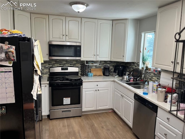 4095 Candea Ct, Colorado Springs, CO 80916 - kitchen with appliances with stainless steel finishes, decorative backsplash, light wood finished floors, and white cabinets