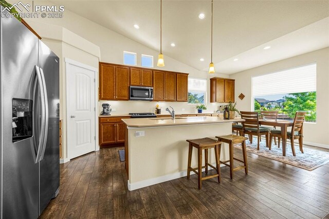 2997 Bright Moon Dr, Colorado Springs, CO 80908 - kitchen with stainless steel appliances, brown cabinetry, dark wood-style floors, healthy amount of natural light, and recessed lighting