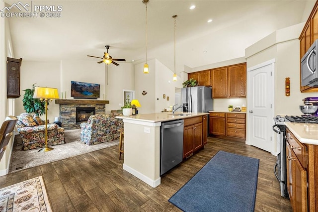 2997 Bright Moon Dr, Colorado Springs, CO 80908 - kitchen featuring stainless steel appliances, open floor plan, brown cabinets, ceiling fan, and dark wood-style floors