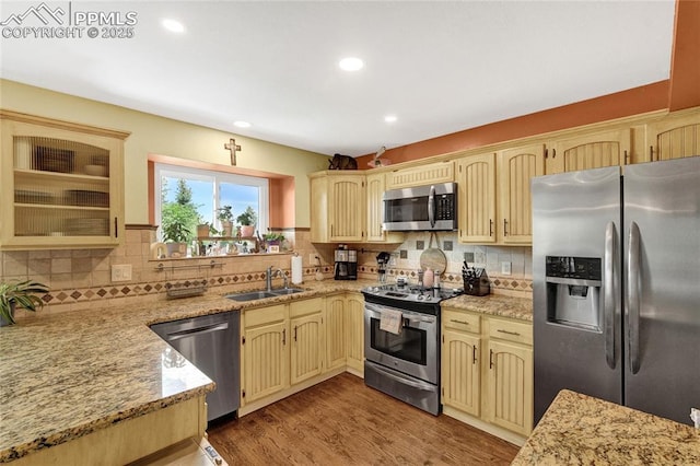 35 Lowick Dr, Colorado Springs, CO 80906 - kitchen featuring appliances with stainless steel finishes, backsplash, recessed lighting, wood finished floors, and light stone countertops