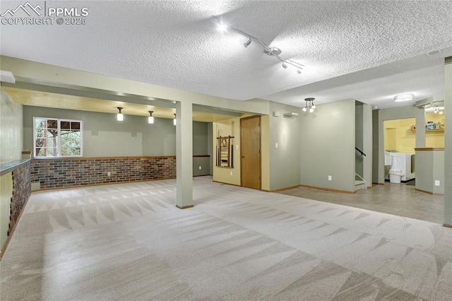 35 Lowick Dr, Colorado Springs, CO 80906 - below grade area with carpet flooring, a textured ceiling, stairs, and track lighting