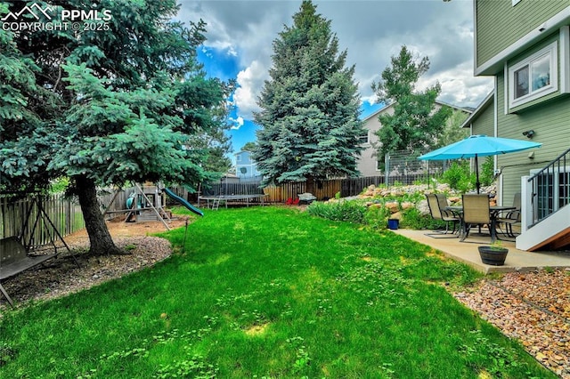 35 Lowick Dr, Colorado Springs, CO 80906 - fenced backyard featuring a playground, a trampoline, and a patio area