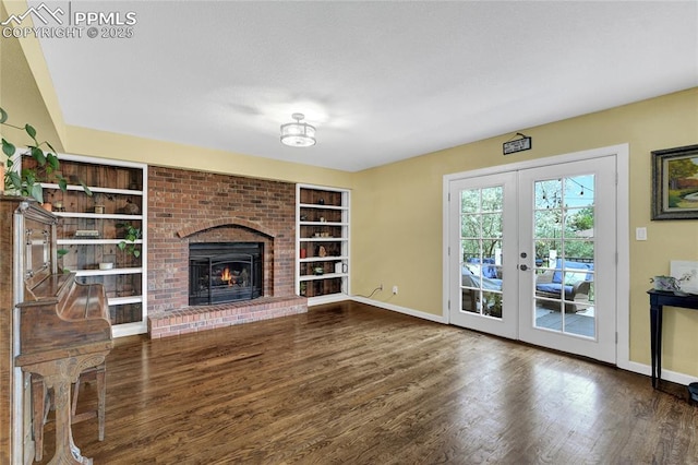 35 Lowick Dr, Colorado Springs, CO 80906 - unfurnished living room with french doors, wood finished floors, built in features, and a brick fireplace