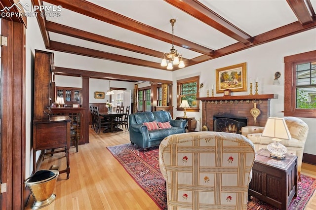 13 2nd St, Colorado Springs, CO 80906 - living room featuring a chandelier, beamed ceiling, wood finished floors, and a brick fireplace