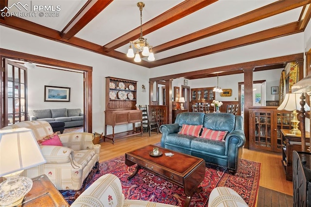 13 2nd St, Colorado Springs, CO 80906 - living room featuring ornate columns, a chandelier, beamed ceiling, wood finished floors, and healthy amount of natural light