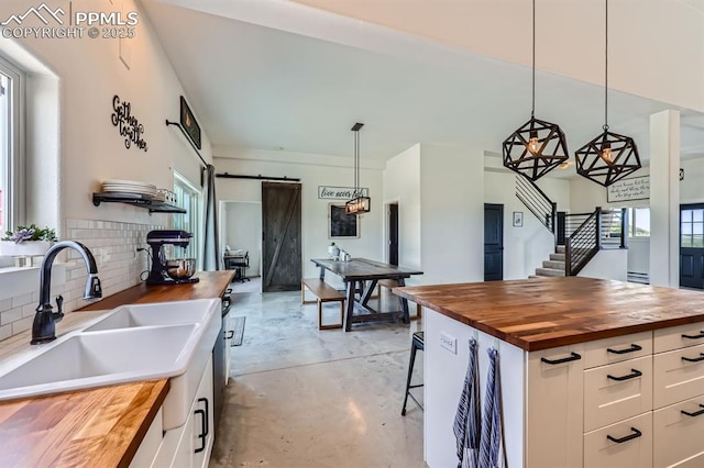 6925 Ht Ranch Trl, Colorado Springs, CO 80908 - kitchen featuring butcher block counters, a barn door, healthy amount of natural light, and concrete floors