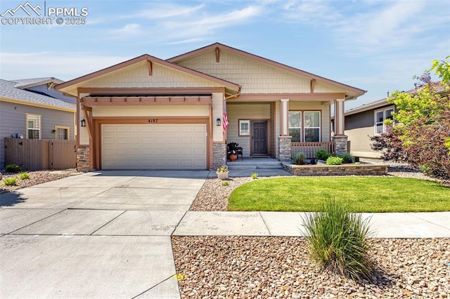 4187 Notch Trl, Colorado Springs, CO 80924 - craftsman house featuring stone siding, an attached garage, concrete driveway, and a porch