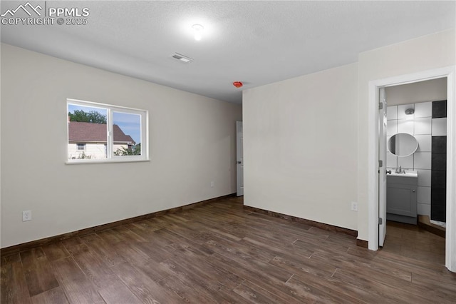 2027 E 14th St, Pueblo, CO 81001 - unfurnished bedroom featuring a sink and dark wood-style floors
