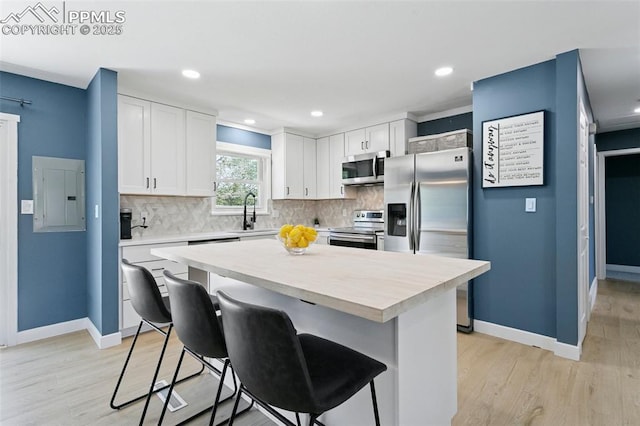 4603 Bella Dr, Colorado Springs, CO 80918 - kitchen with appliances with stainless steel finishes, electric panel, a breakfast bar area, light countertops, and recessed lighting