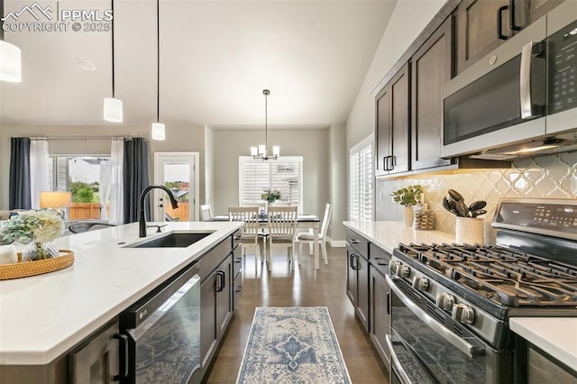6792 David Anthony Ct, Colorado Springs, CO 80922 - kitchen with appliances with stainless steel finishes, decorative backsplash, light countertops, a chandelier, and pendant lighting