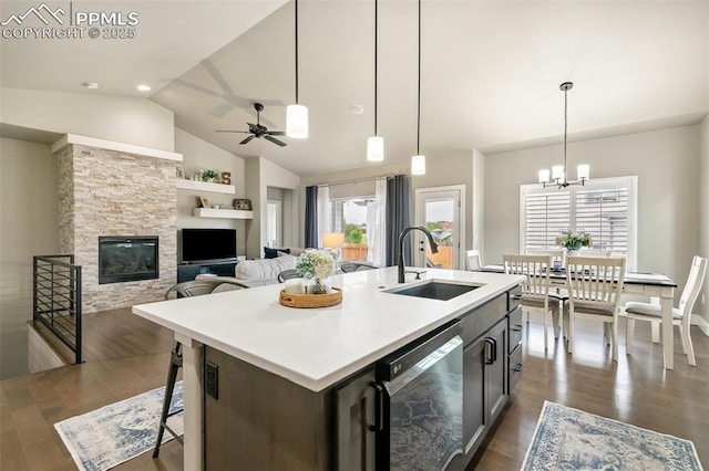 6792 David Anthony Ct, Colorado Springs, CO 80922 - kitchen with dishwasher, a stone fireplace, vaulted ceiling, and dark wood-style floors