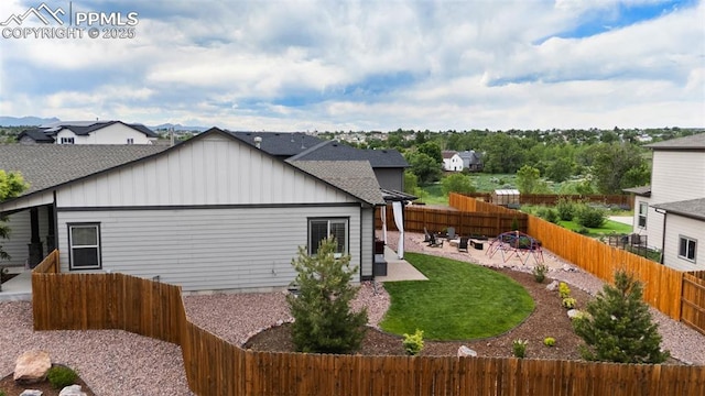 6792 David Anthony Ct, Colorado Springs, CO 80922 - view of side of property with board and batten siding, a patio area, a fenced backyard, a residential view, and a shingled roof