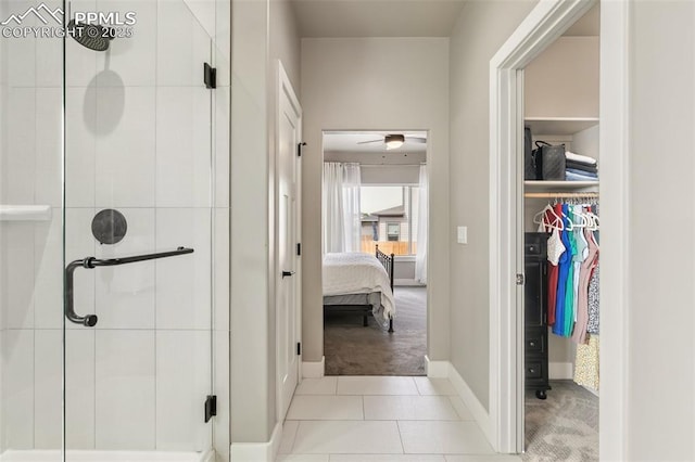 6792 David Anthony Ct, Colorado Springs, CO 80922 - bathroom featuring a stall shower, ensuite bathroom, a walk in closet, ceiling fan, and tile patterned floors
