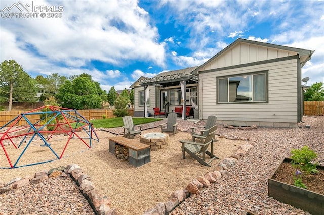 6792 David Anthony Ct, Colorado Springs, CO 80922 - rear view of house featuring a fire pit, a fenced backyard, board and batten siding, a playground, and a patio area