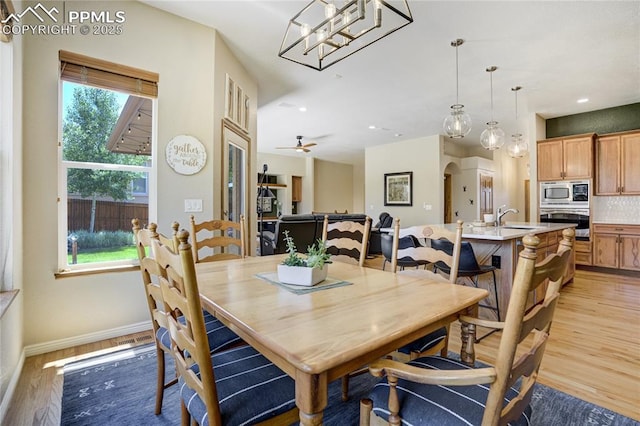 5763 Show Down Ln, Colorado Springs, CO 80923 - dining room with light wood-style flooring, arched walkways, and recessed lighting