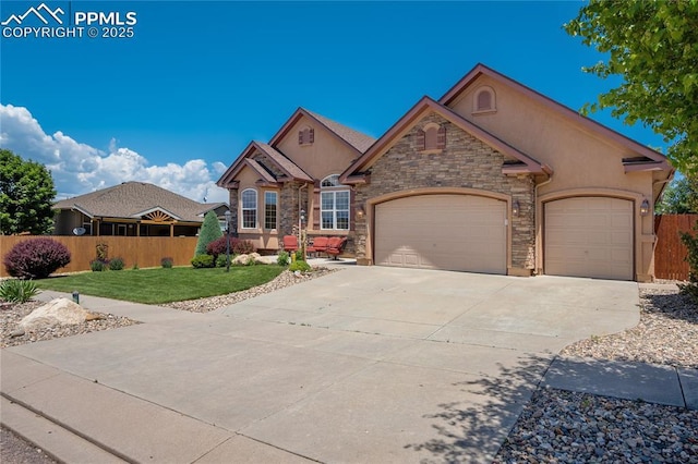 5763 Show Down Ln, Colorado Springs, CO 80923 - view of front of property with an attached garage, concrete driveway, stucco siding, and stone siding