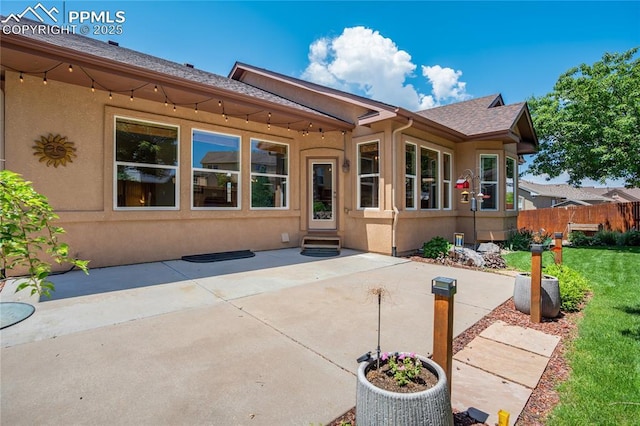 5763 Show Down Ln, Colorado Springs, CO 80923 - rear view of property featuring stucco siding, a patio, roof with shingles, and entry steps