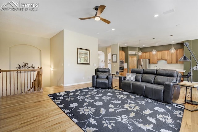 5763 Show Down Ln, Colorado Springs, CO 80923 - living room with light wood-style floors, a ceiling fan, arched walkways, and recessed lighting