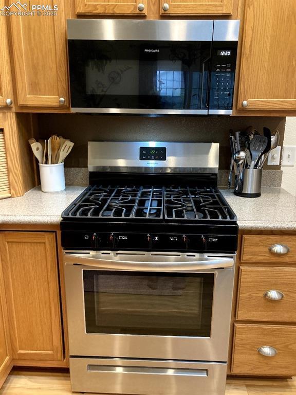 968 Samuel Pt, Colorado Springs, CO 80906 - kitchen with stainless steel appliances, light countertops, and brown cabinetry