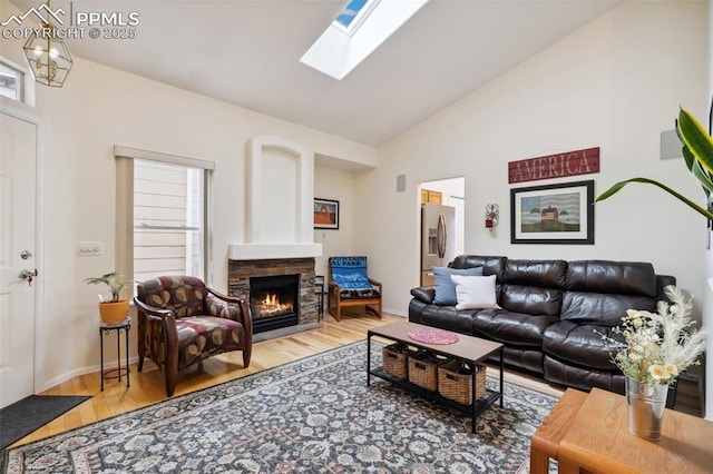 968 Samuel Pt, Colorado Springs, CO 80906 - living area featuring vaulted ceiling, a fireplace, light wood-type flooring, and a skylight