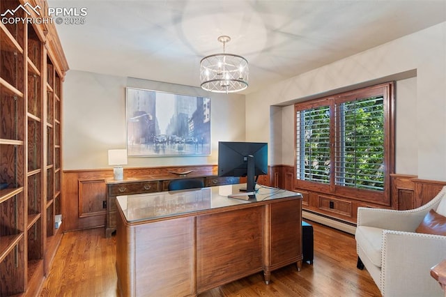 155 Grayson Ct, Colorado Springs, CO 80906 - office space with a wainscoted wall, a baseboard heating unit, a chandelier, light wood-type flooring, and wood walls